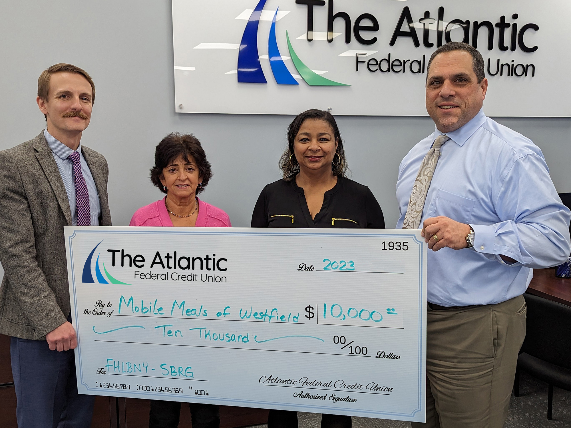 Photo of representatives from Mobile Meals of Westfield accepting an oversized check of $10,000 through the FHLBNY SBRG from representatives of The Atlantic