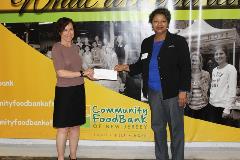 Holding check for $1,500 donation to The Community FoodBank of New Jersey Holding check for $1,500 donation to The Community FoodBank of New Jersey