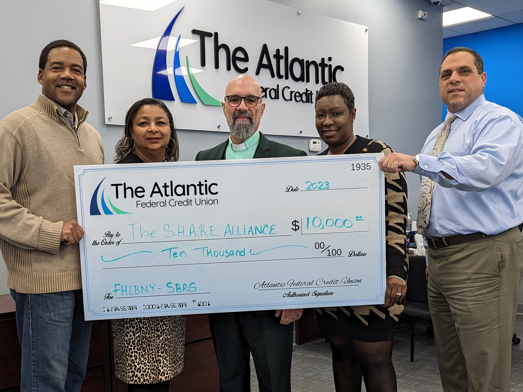 Photo of representatives from The SHARE Alliance accepting an oversized check of $10,000 through the FHLBNY SBRG from representatives of The Atlantic